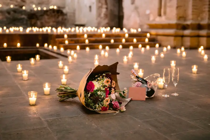 Un ramo de novia apoyado en el suelo entre velas encendidas