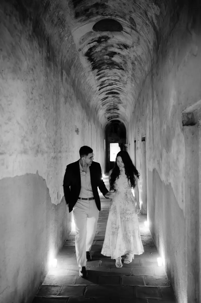 La pareja caminando por un corredor colonial